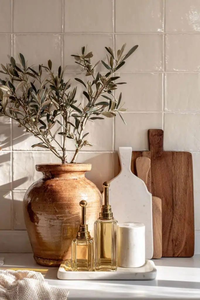 Decorative setup with a vase, bottles, and cutting boards on a tiled wall background