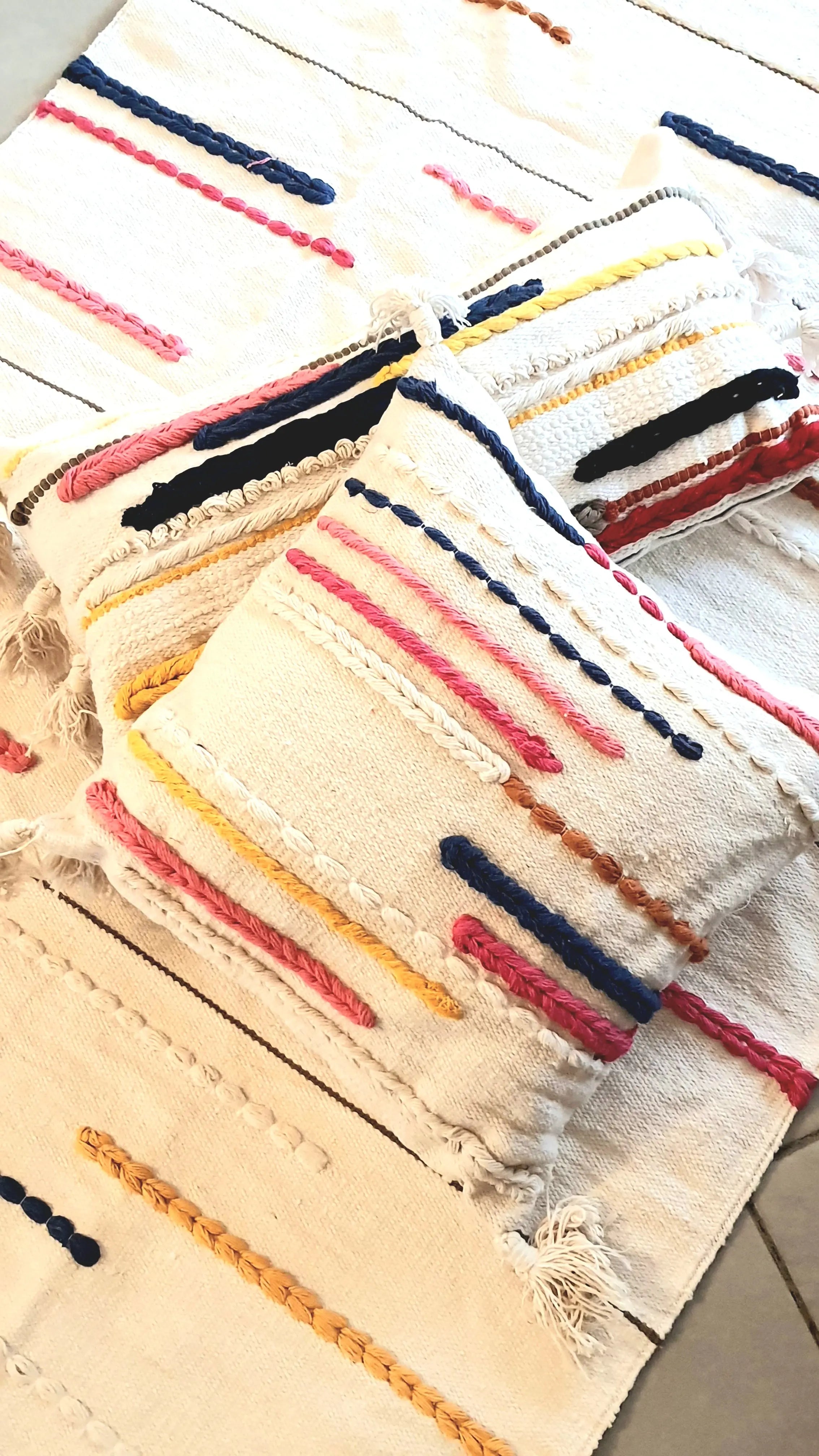 Close-up of a woven fabric with colorful stripes on a wooden surface