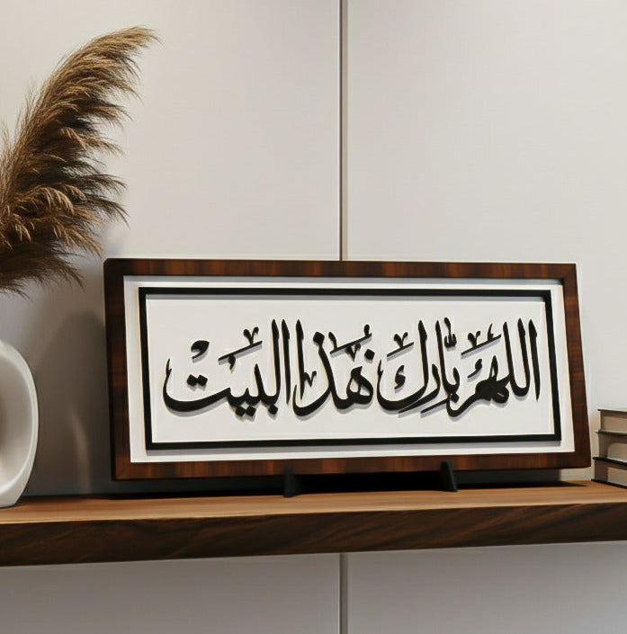 Framed Arabic calligraphy on a wooden shelf with decorative elements.