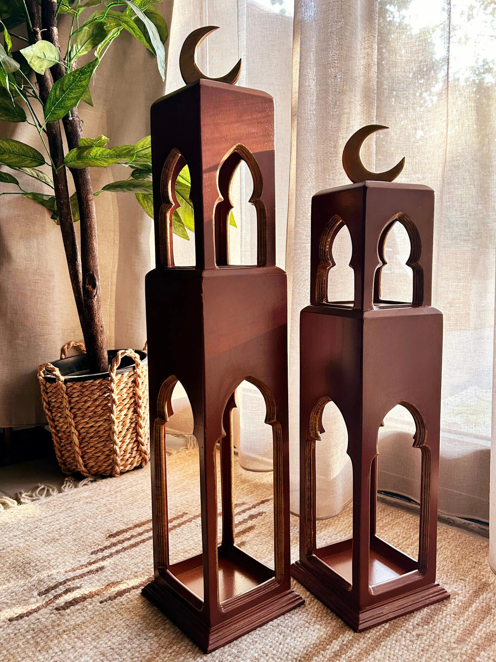 Two wooden lanterns with crescent moon design on a carpeted floor.