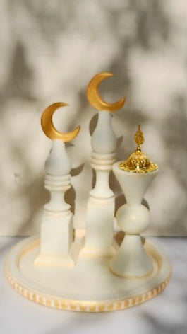 Decorative set with white pillars and gold crescent moons on a blurred background