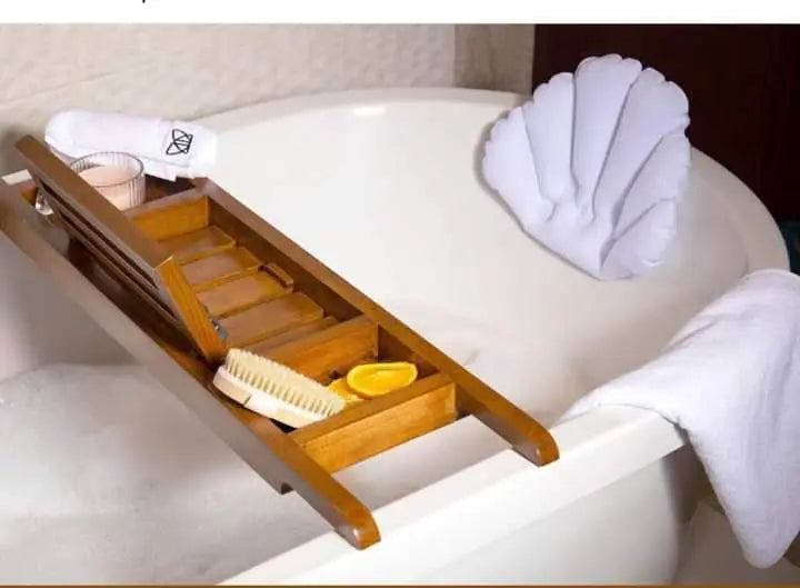 Wooden bathtub caddy with items on a white bathtub