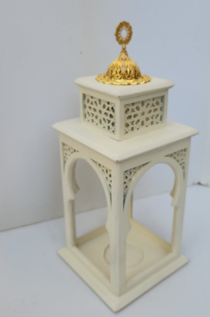 Decorative white lantern with a gold top on a plain background