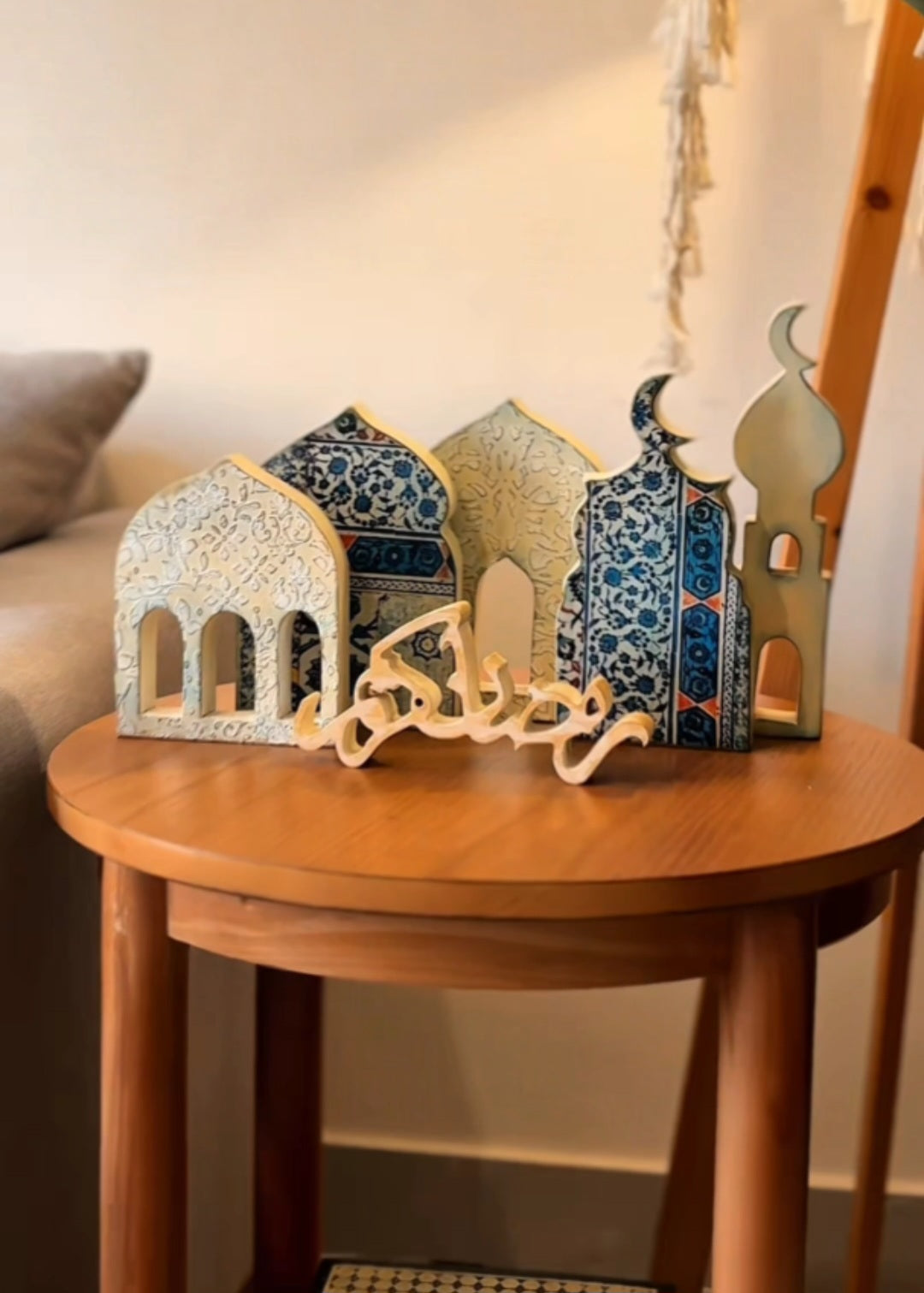 Decorative arches and calligraphy on a wooden table with a neutral background