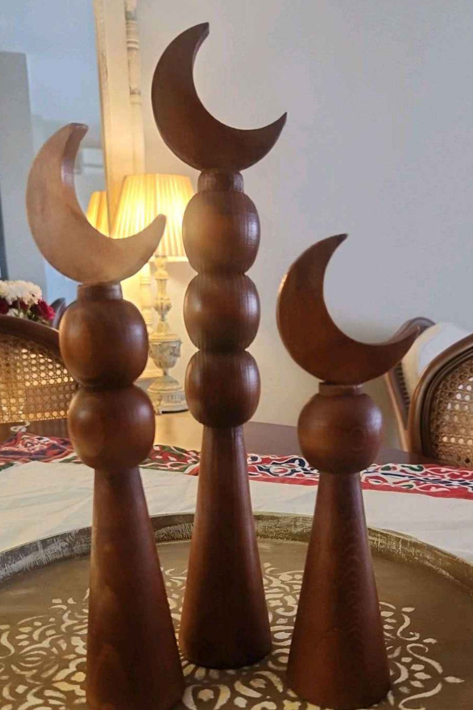 Wooden decorative items with crescent moon design on a patterned surface.