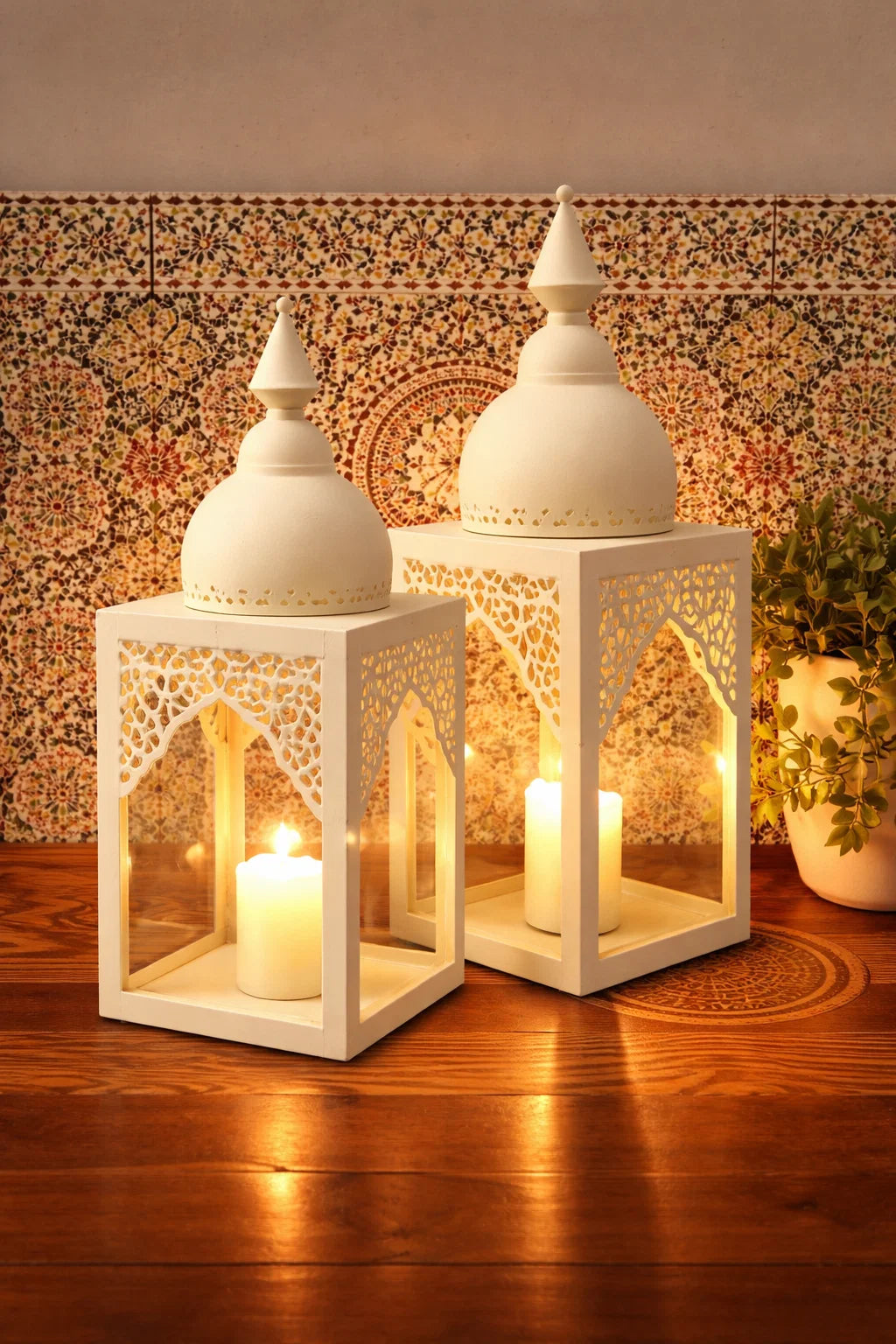 Two white lanterns with lit candles inside on a wooden surface.