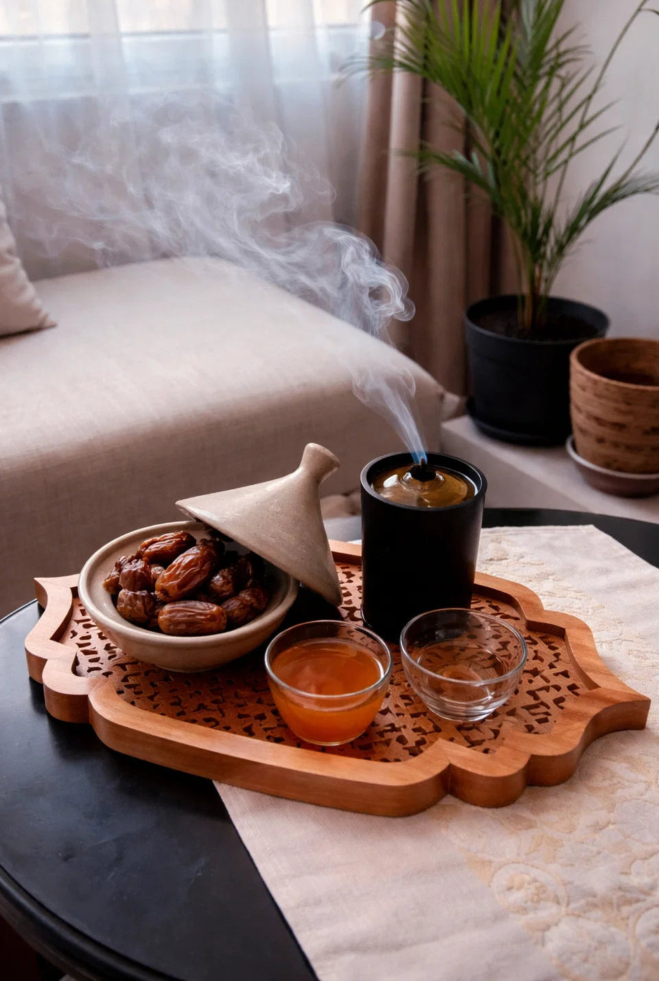 Tray with dates, coffee, and a smoking device on a table with a blurred background