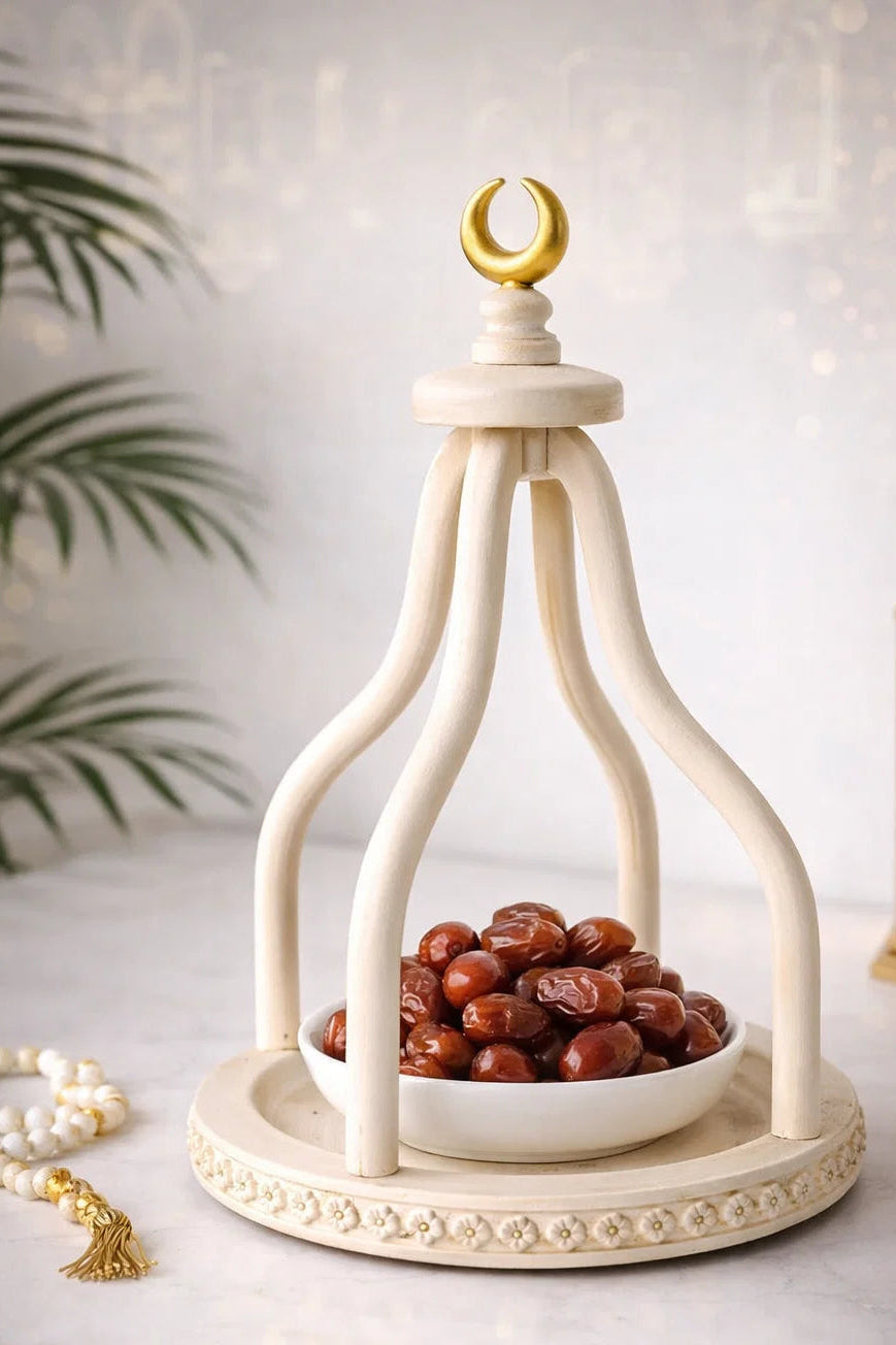 Decorative lantern with a bowl of dates and a gold crescent moon on a light background
